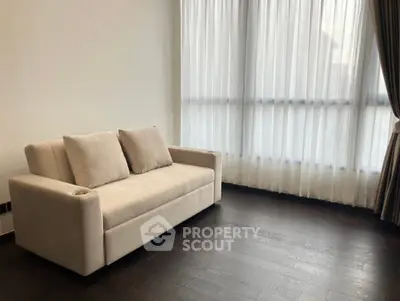 Spacious living room with elegant sofa and large windows for natural light.