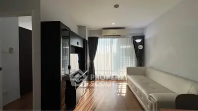 Modern living room with sleek furniture and natural light, featuring a stylish entertainment unit and cozy sofa.