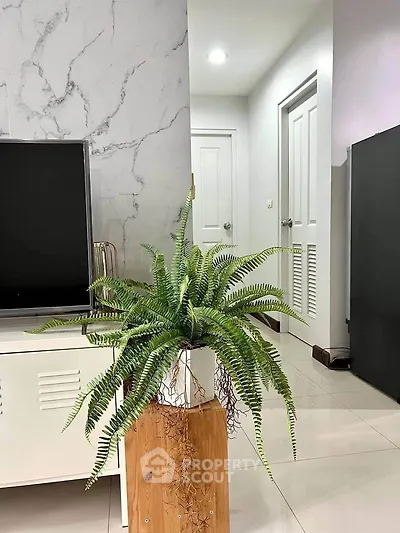 Modern living room with stylish decor and lush indoor plant enhancing the ambiance.