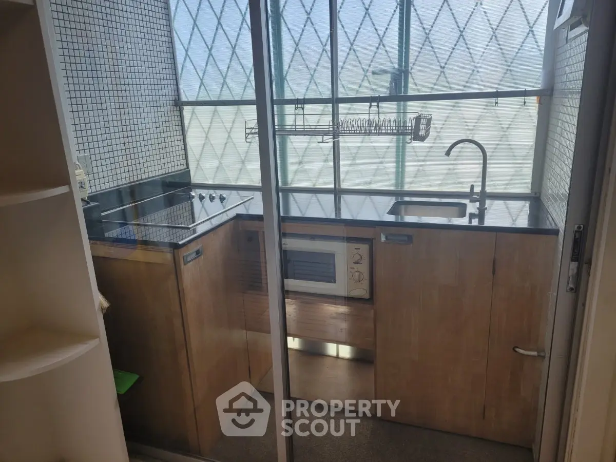 Compact kitchen with modern appliances and glass sliding door
