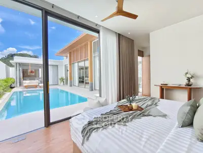 Luxurious bedroom with pool view in modern villa, featuring elegant decor and large glass doors for natural light.