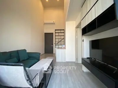 Modern living room with high ceiling and stylish furniture in a contemporary apartment.