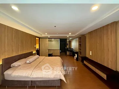 Spacious modern bedroom with elegant wood paneling and ambient lighting