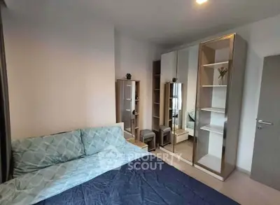 Modern bedroom with stylish mirrored wardrobe and cozy bedding