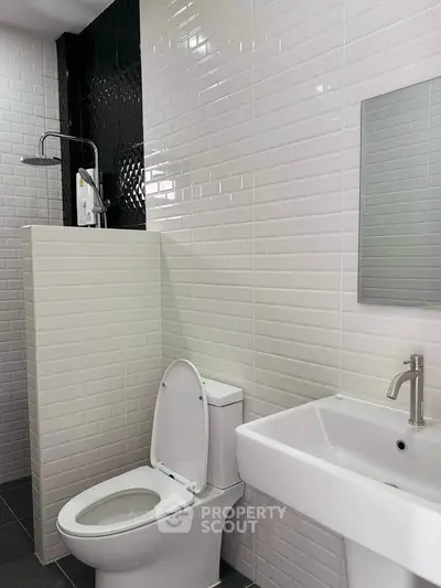 Modern bathroom with sleek white tiles and contemporary fixtures.
