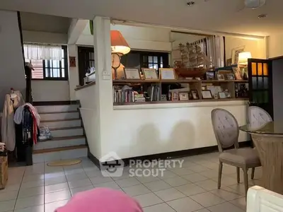 Cozy living room with staircase and decorative ship model, ideal for family gatherings.