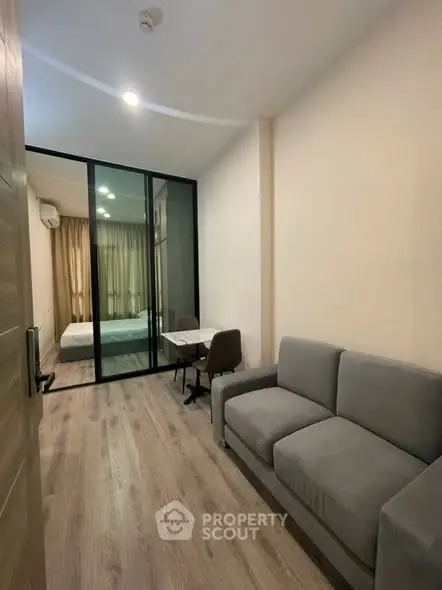 Modern apartment with cozy living room and glass partitioned bedroom