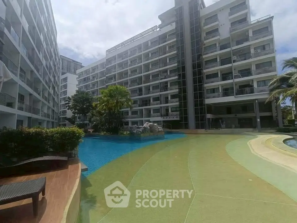 Modern apartment complex with pool and lush landscaping, ideal for luxury living.