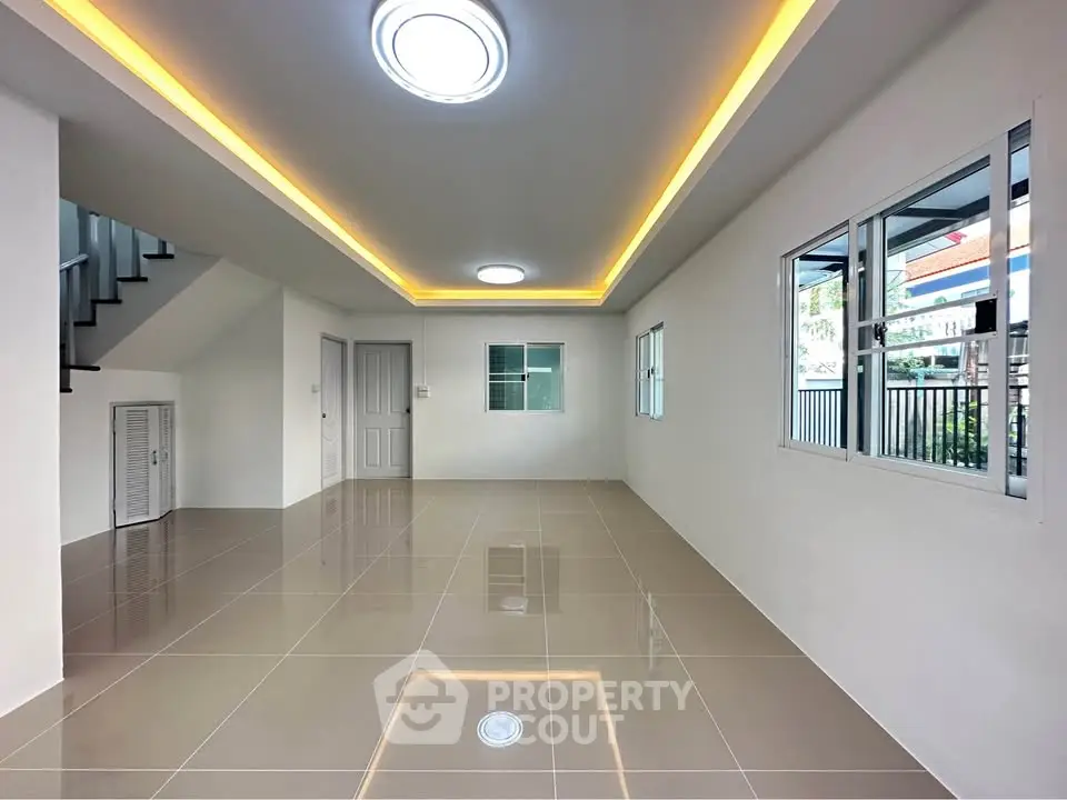Spacious modern living room with sleek tile flooring and recessed lighting