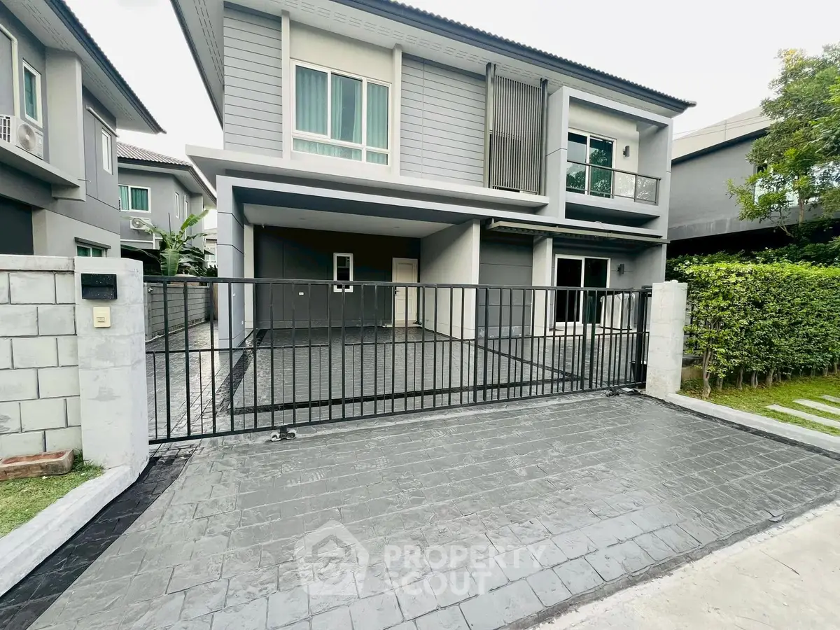 Modern two-story house with gated driveway and sleek exterior design
