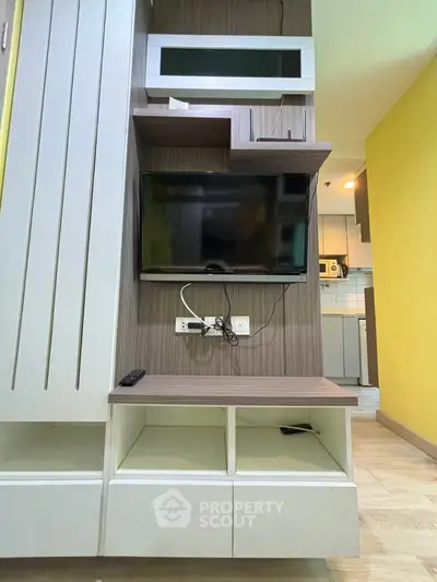Modern living room with wall-mounted TV and stylish shelving in cozy apartment