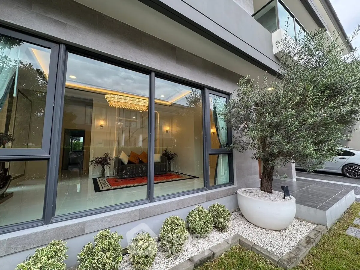 Luxurious modern home exterior with large windows and elegant interior view