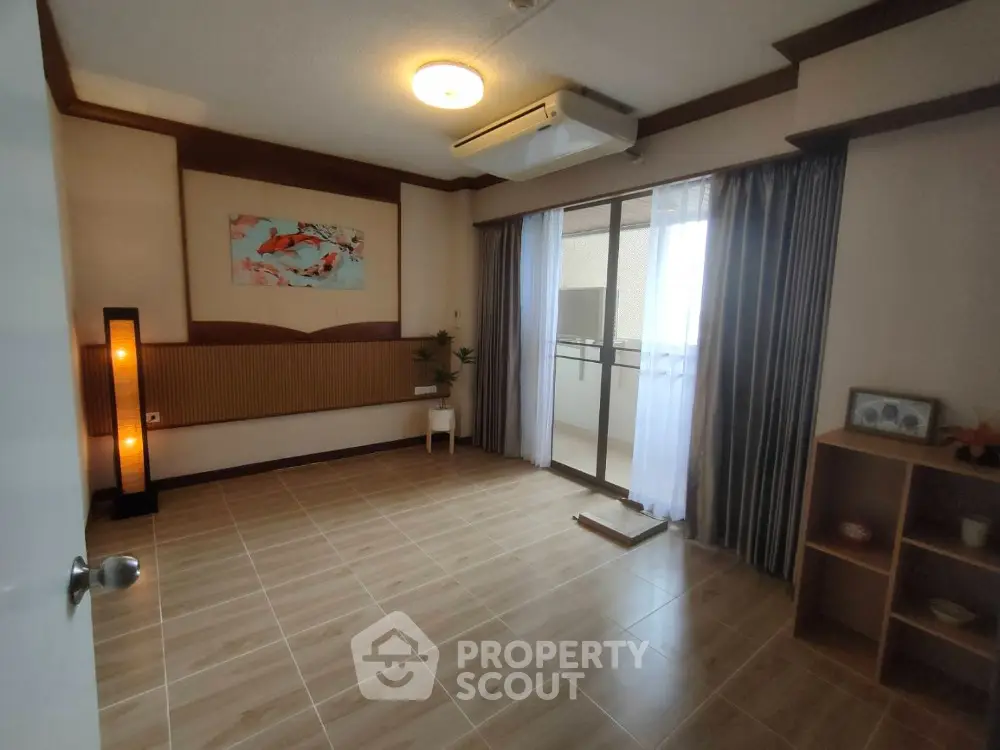 Spacious living room with modern decor and balcony access