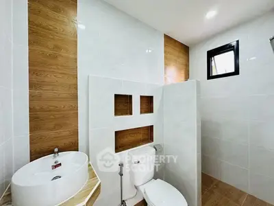 Modern bathroom with stylish wood accents and sleek white fixtures.
