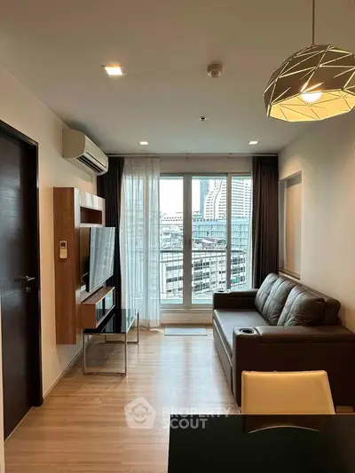 Modern living room with city view, featuring sleek furniture and stylish lighting in a high-rise apartment.