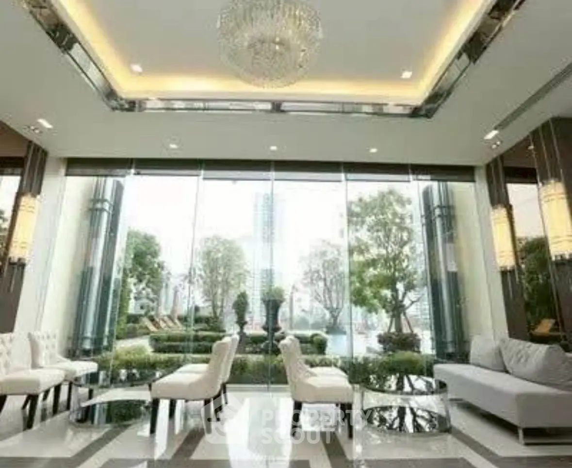 Luxurious modern living room with floor-to-ceiling windows and elegant chandelier overlooking a lush garden.