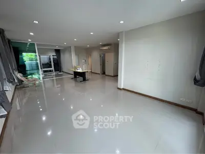 Spacious modern living room with sleek tile flooring and large windows.