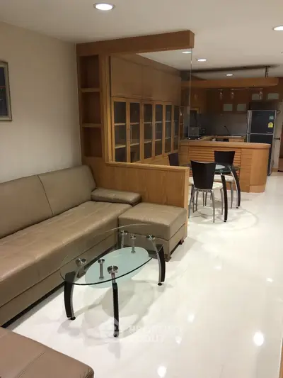 Spacious living room with modern kitchen and elegant glass table