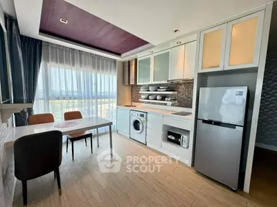 Modern kitchen with dining area, featuring sleek appliances and large windows for natural light.