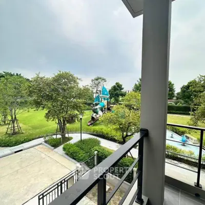Spacious balcony with scenic view of lush green park and playground, perfect for family living.