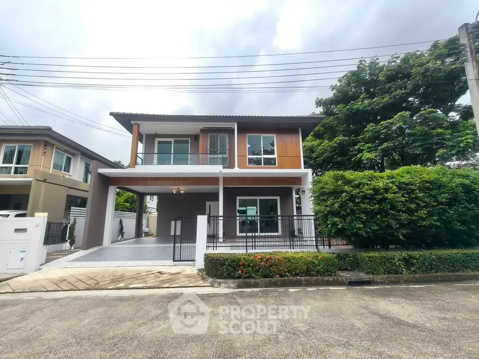 Modern two-story house with spacious driveway and lush greenery in a serene neighborhood.