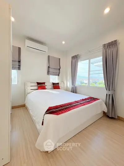 Bright and cozy bedroom with modern decor and large windows