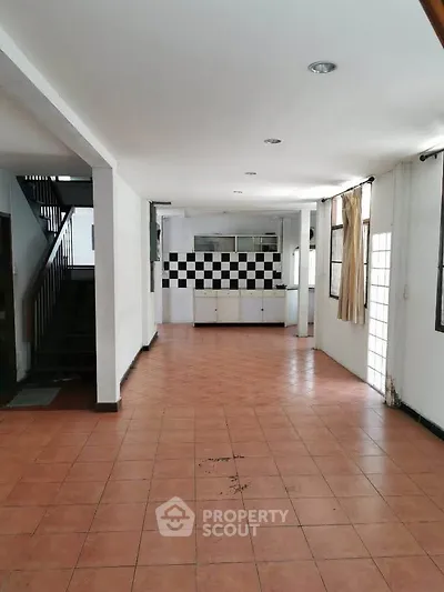 Spacious open-plan living area with tiled flooring and modern kitchen
