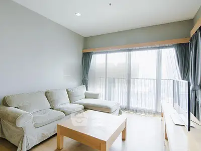 Bright and spacious living room with large windows and modern furniture.
