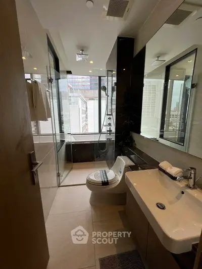 Modern bathroom with city view, featuring glass shower and sleek fixtures.