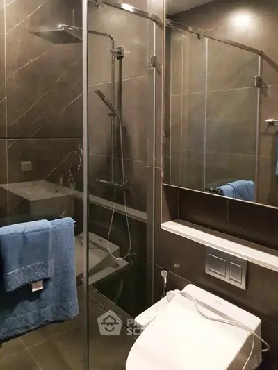 Modern bathroom with sleek shower and toilet in contemporary design.
