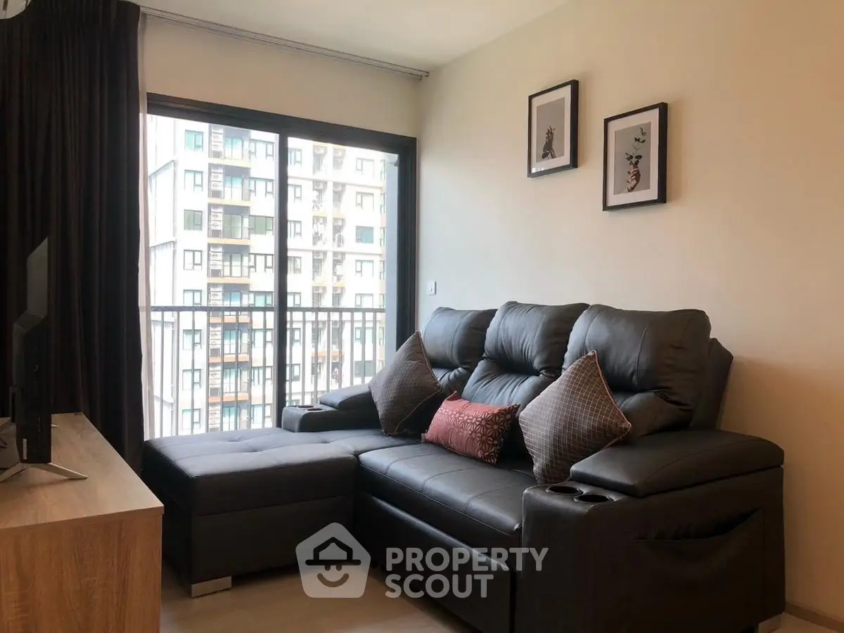 Modern living room with cozy leather sofa and balcony view in urban apartment.