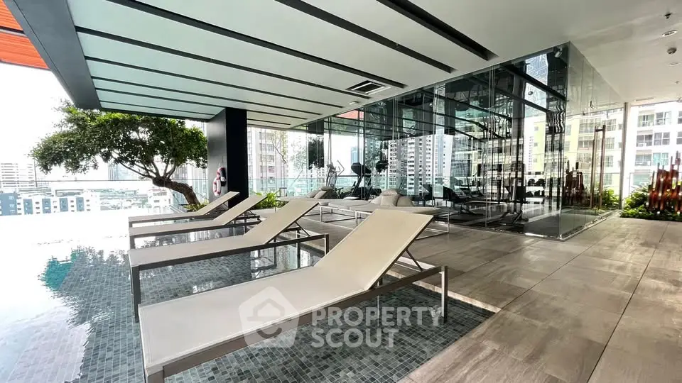 Luxurious rooftop pool area with modern lounge chairs and city skyline view.