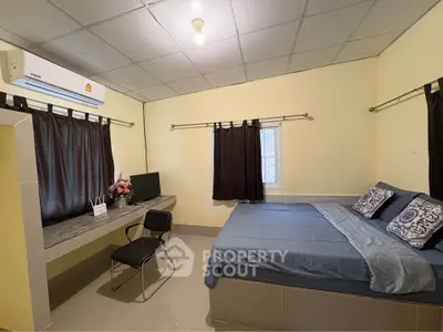 Cozy bedroom with modern decor and air conditioning, perfect for relaxation.