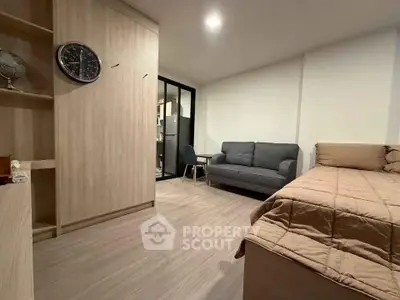 Modern bedroom with cozy bed, stylish sofa, and sleek wooden furniture in a contemporary apartment.