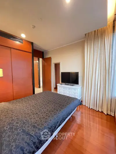Spacious bedroom with elegant wooden flooring and modern decor