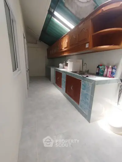 Spacious kitchen with ample storage and natural light, featuring a closed layout and modern appliances.