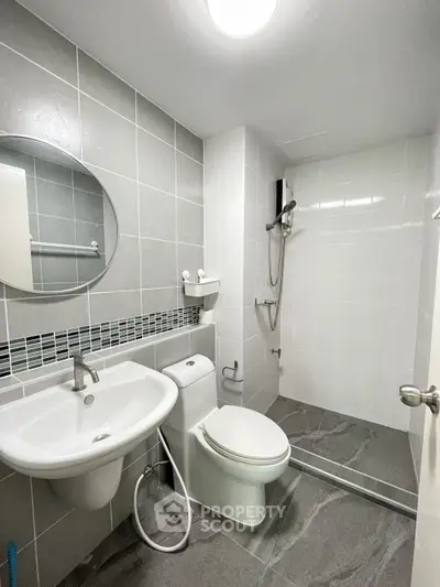 Modern bathroom with sleek fixtures and walk-in shower in contemporary apartment.