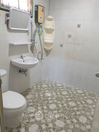 Compact bathroom with modern fixtures and patterned tile flooring.