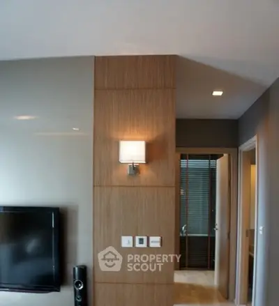 Modern living room with sleek wall paneling and mounted TV, showcasing contemporary design.