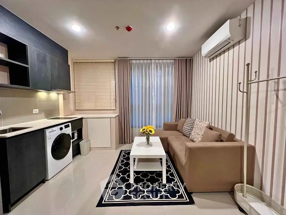 Modern living room with stylish decor, featuring a cozy sofa, washing machine, and elegant lighting.