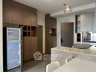 Modern kitchen with open fridge and sleek cabinetry in a contemporary apartment.