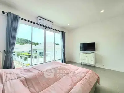 Bright bedroom with large window and balcony view, featuring modern decor and natural light.