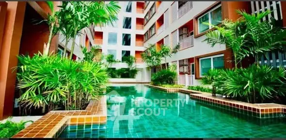 Luxurious condominium with a stunning pool surrounded by lush greenery, perfect for relaxation and leisure.