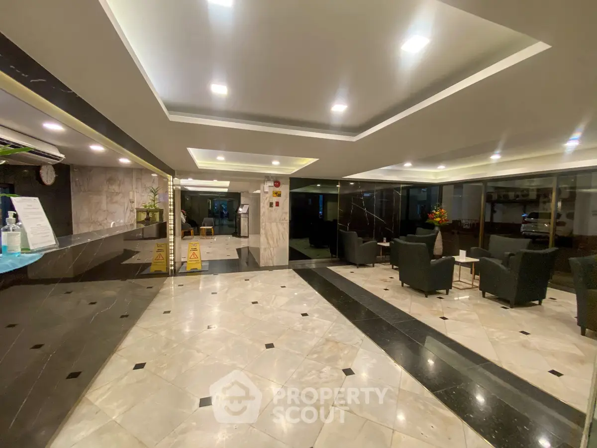 Luxurious lobby with elegant marble flooring and modern seating area in upscale building.