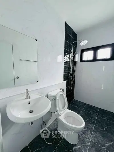 Modern bathroom with sleek fixtures and stylish black and white tile design.