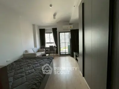 Modern studio apartment with large windows and sleek furnishings