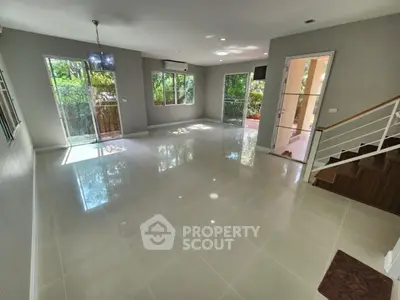 Spacious modern living room with large windows and glossy tile flooring