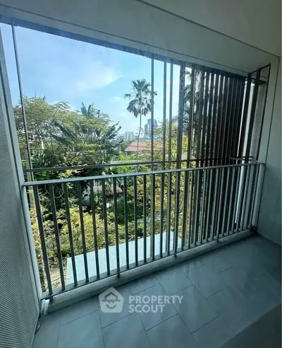 Spacious balcony with lush green view and modern railing design.
