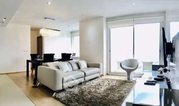 Modern living room with elegant decor and large windows offering natural light