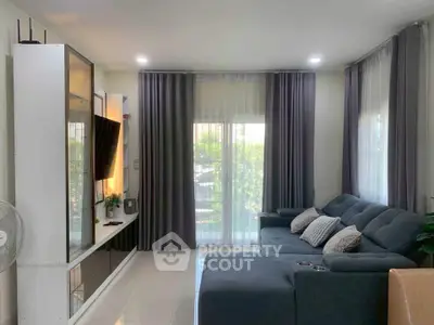 Modern living room with sleek furniture and large windows for natural light.